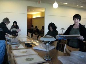 Laying out tables of beautiful artwork to arrange for hanging.