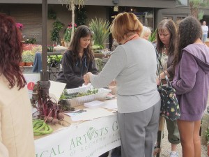 Tania Marien and visitors to the BAGSC Interactive Table. Kids of all ages used fruits and vegetables to create stamp art.